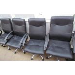 A set of four faux leather office chairs together with another office chair