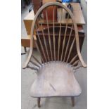 A spindle back elbow chair with a solid seat on turned legs