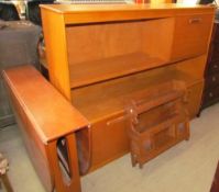 A teak drop leaf dining table together with a teak wall unit and a hanging cupboard