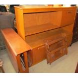 A teak drop leaf dining table together with a teak wall unit and a hanging cupboard