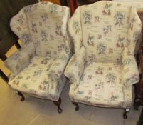 A pair of upholstered wing back elbow chairs