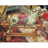 A dapple grey rocking horse on a wooden base,