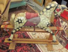 A dapple grey rocking horse on a wooden base,