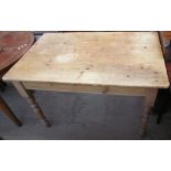 A pine kitchen table with a rectangular top on four turned legs