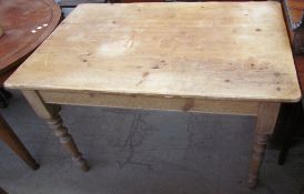 A pine kitchen table with a rectangular top on four turned legs