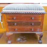 An early 20th century mahogany piano stool with a pad upholstered top above three drawers with drop