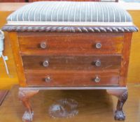 An early 20th century mahogany piano stool with a pad upholstered top above three drawers with drop