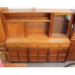 A teak dining room suite comprising a wall unit,