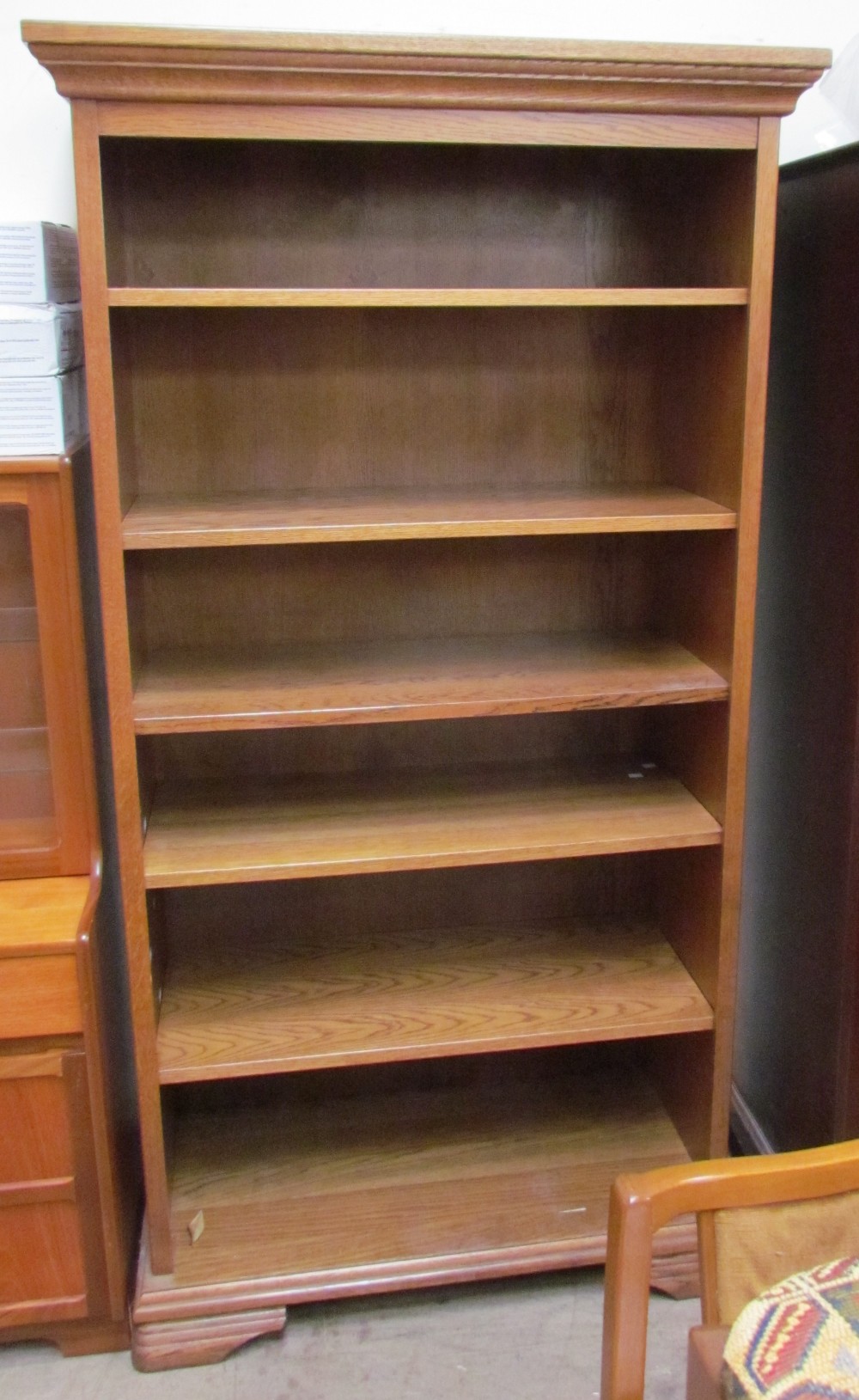 A 20th century oak bookcase the moulded cornice above open shelves
