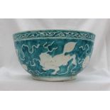 A Chinese porcelain bowl, with a turquoise ground depicting dogs of foo chasing balls,