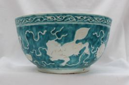 A Chinese porcelain bowl, with a turquoise ground depicting dogs of foo chasing balls,