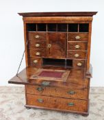 An 18th century walnut secretaire a abatant, the moulded cornice above a cushion drawer,