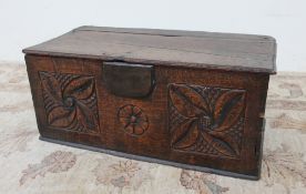 An 17th century oak bible box, the planked rectangular top above a floral panelled front,