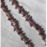 A pearl and amethyst necklace set with thirty five pearls and amethyst chips to a lobster claw