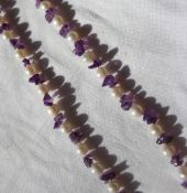 A pearl and amethyst necklace set with thirty five pearls and amethyst chips to a lobster claw