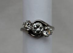 A Three stone diamond ring, the central brilliant cut diamond approximately 0.