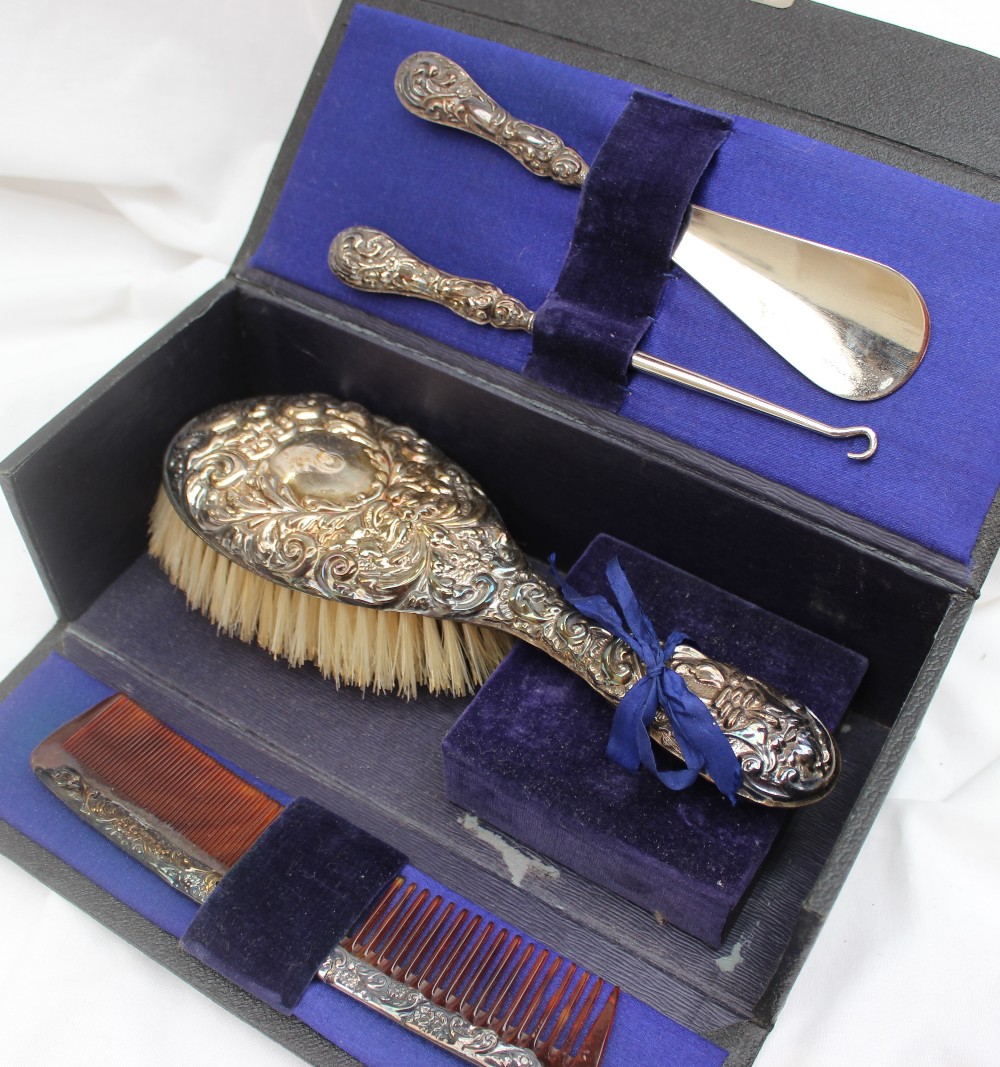 A George V silver handled travelling set, comprising a clothes brush, comb,