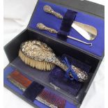 A George V silver handled travelling set, comprising a clothes brush, comb,