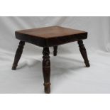 A 19th century Elm seated milking stool, the rectangular top on four splayed turned legs,