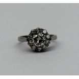 A diamond cluster ring set with a central round brilliant cut diamond approximately 0.