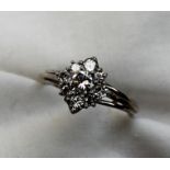 A diamond cluster ring set with a central round brilliant cut diamond approximately 0.