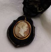 A shell cameo brooch / pendant carved with a lady's head in profile to an unmarked yellow metal