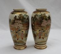 A pair of Japanese satsuma pottery vases decorated with geisha under a cherry blossom tree and