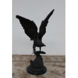 After Jules Moigniez A bronze model of an eagle perched on a branch with a circular green marble