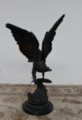 After Jules Moigniez A bronze model of an eagle perched on a branch with a circular green marble