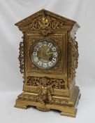 A Gilt metal mantle clock, with a pointed arched top above a cartouche and swags,