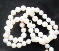 A pearl necklace set with sixty-two graduated individually knotted pearls to a yellow metal clasp