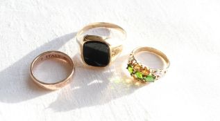 A 9ct yellow gold signet ring, set with an onyx panel together with a garnet,