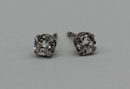 A pair of solitaire diamond stud earrings, with round brilliant cut diamonds each approximately 0.