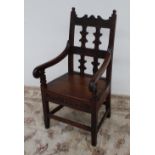 A 19th century oak elbow chair, the back rail carved with initials "I.M.