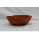 A Roman red ground terracotta bowl, Arretine ware, with a ridged body on a raised foot,