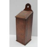 An 18th century oak candle box, with an arched pierced top above a sloping fall and rectangular box,
