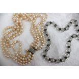 A four strand pearl necklace set with regular pearls to a yellow metal pearl set clasp and another