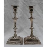 A pair of George III silver candlesticks, with a gadrooned and knopped stem, with a square base,