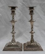 A pair of George III silver candlesticks, with a gadrooned and knopped stem, with a square base,