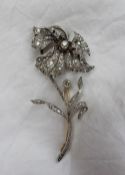 An Edwardian diamond brooch, in the form of a flower head and stem,