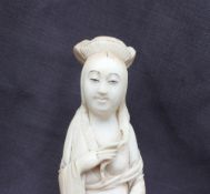 A 19th century Japanese ivory figure of a Geisha with kimono slipping off her shoulder and fan in