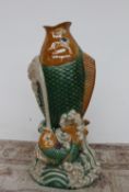 A large tin glazed earthenware fish vase, depicting a fish leaping from the waves,