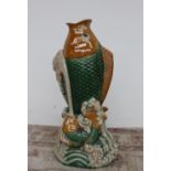 A large tin glazed earthenware fish vase, depicting a fish leaping from the waves,