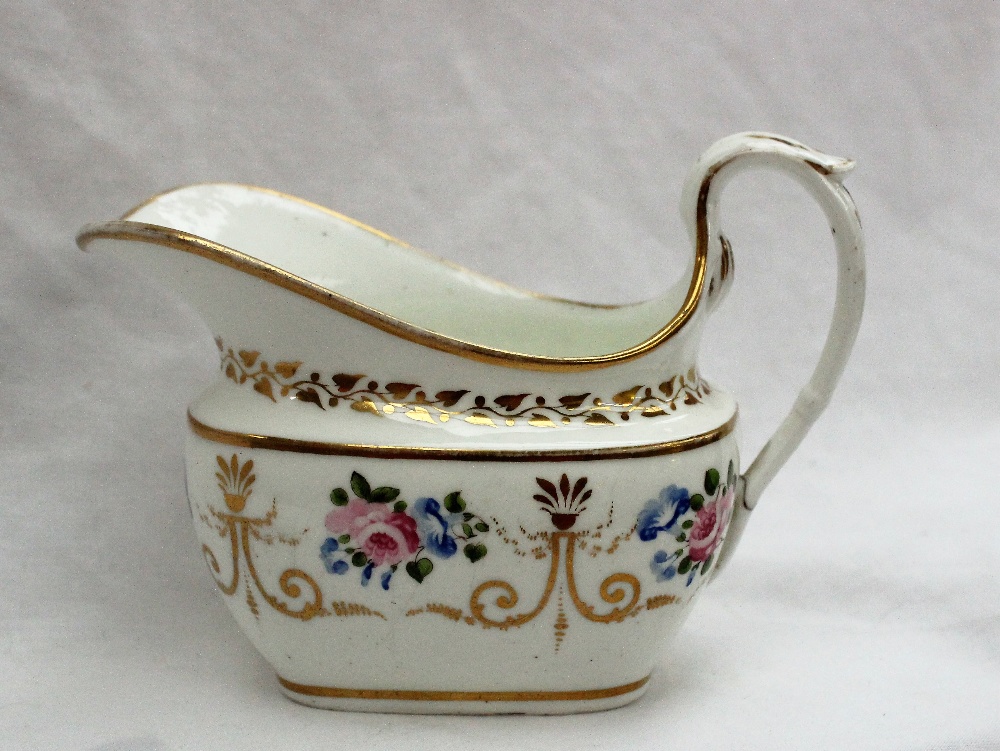 A Swansea porcelain cream jug, painted with roses and gilt swags and a scrolling handle,