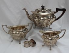 A George V three piece silver tea set, comprising a lobed tapering teapot,