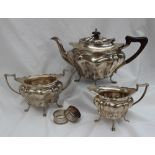 A George V three piece silver tea set, comprising a lobed tapering teapot,