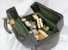 A leather travelling case, fitted with various silver topped bottle, bone and ivory handled brushes,