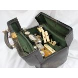 A leather travelling case, fitted with various silver topped bottle, bone and ivory handled brushes,