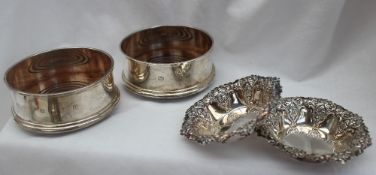 A pair of Elizabeth II silver bottle coasters of plain ring turned form with a wooden base,