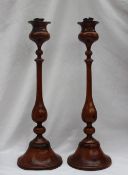 A pair of 19th century turned treen candlesticks with a baluster stem and a spreading foot, 39.